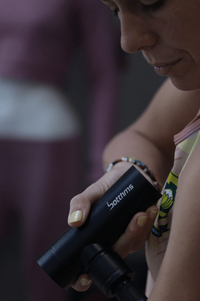person trying botthms massage gun on left hand